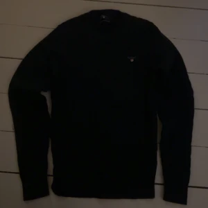 Svart stickad tröja från GANT - Svart stickad tröja från GANT med diskret logga på bröstet. Helt ny, använd en gång. Skriv för fler bilder
