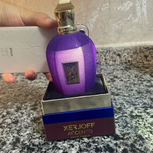 Xerjoff Accento Eau de Parfum - Lyxig parfym med unik lila flaska från Xerjoff. Accento Eau de Parfum ger en exklusiv känsla och sticker ut i samlingen. Perfekt för dig som vill ha något speciellt och trendigt på hyllan. (Oanvänd)