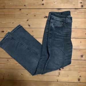  slim jeans J & J  - Snygga svarta slim-fit jeans från Jack & Jones, modell Glenn. Jeansen har klassisk femficksdesign, smal passform och är tillverkade i stretchigt denim för extra komfort. Perfekt för dig som gillar en modern och stilren look.