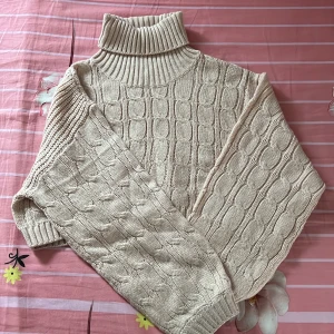 Beige polotröja från H&M Divided - Säljer en beige polotröja från H&M Divided i kabelstickat mönster. Tröjan har hög polokrage, långärmad modell och är riktigt mysig och varm. Perfekt för kyliga dagar och enkel att matcha med jeans eller kjol.