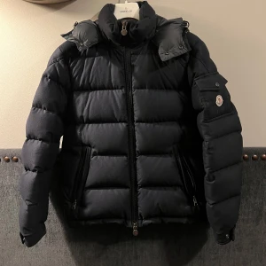 Moncler Montgenevre jacka - Nästintill helt perfekt moncler jacka som bara sitter och samlar damm. Storlek 2 (medium) och har skötts väldigt bra. Det finns två små litet hål på utsidan som inte är syndlig om man inte verkligen letar efter den. Jag var hos skräddaren och han fixar det åt mig. Köptes från farfetch dryga 2021.  Kan skicka mer bilder osv på pm.  Nypris 23k
