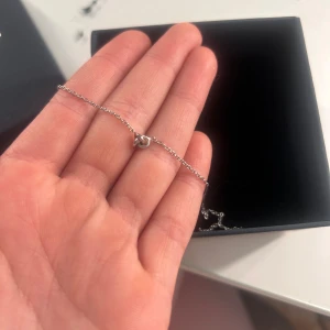 Drakenberg Sjölin Le Knot halsband - Supersnyggt och stilrent halsband från Drakenberg Sjölin, modell Le Knot. Kedjan är tunn och i silverfärg med en liten knut som hänge. Perfekt för dig som gillar minimalistiska smycken med en twist. Priset kan diskuteras