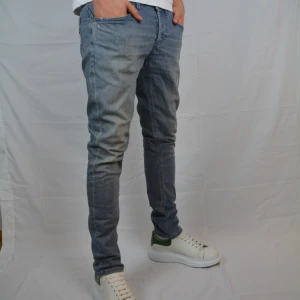 Dondup George - Riktigt feta blåa Dondup jeans i modellen George med slitningar och snygg tvätt. Jeansen är i storlek 33 och är i väldigt gott skick, dvs har inga tecken på användning.                  Innerbensmått:75cm.    Midjemått: 42cm.          Vid frågor eller funderingar är det bara att höra av sig, och kom ihåg, alltid 14 dagars ångerrätt hos oss på Revalo!