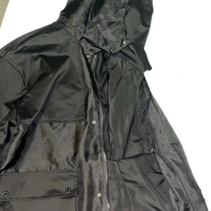 Svart vindjacka - Svart vindjacka med monogrammönster till salu. Otroligt fin i nyskick. Skriv för mer info.