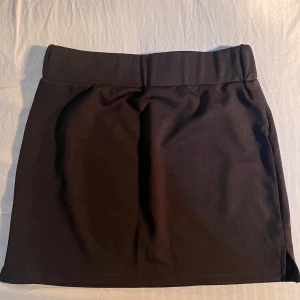 Svart minikjol från Cider med slits - Helt oanvänd svart kortkjol från Cider, köpt på vinted men den passade tyvärr inte. Den har slits på 4 cm på båda sidor. Midjemått: 33 cm, längd: 35 cm. Det är bara att skriva om du har några frågor!☺️