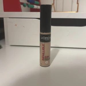 L'Oréal Infallible Concealer 325 Cool Rose - L'Oréal Infallible More Than Concealer i nyansen 325 Cool Rose. Flytande concealer med svart lock och beige färg, ger full täckning och håller upp till 24 timmar. Perfekt för att täcka mörka ringar och ojämnheter. Smidig applikator för enkel användning.( aldrig använt helt ny