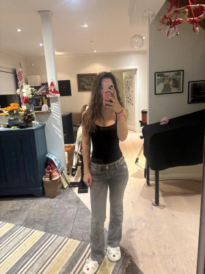 Grå bootcut jeans med detaljer - Gina Young storlek 158. Snygga grå jeans med bootcut passform och låg midja. Jeansen har coola detaljer på bakfickorna med knappar och dekorativa sömmar. 