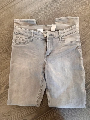 Skinny jeans 146 - Snygga ljusgrå skinny jeans från &Denim med klassisk femficksdesign och dragkedja. Jeansen har en smal passform och är tillverkade i mjukt denimtyg. Storlek 146.