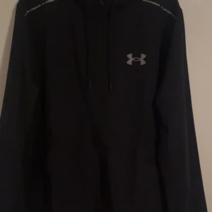 Under Armour windbreaker  - En Under Armour windbreaker i helt nytt skick. Den är inte smutsig och har inte gått sönder någonstans och den har fortfarande all sin färg kvar alltså så ser den helt ny ut. Säljes på grund av att den inte passar och går inte att returnera längre. Nypris på jackan ligger på 1100 kr.