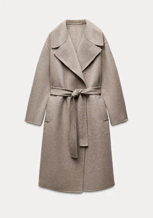 Beige ullkappa med skärp från Zara XS - Stilren beige kappa i ull från Zara i storlek XS. Lång modell med bred krage, knytskärp i midjan och raka fickor. Ofodrad. Tillverkad i mjukt ullblandat material, perfekt för höst, vinter och vår. Enkel och clean look som passar till allt. Som ny! Använd en gång. 