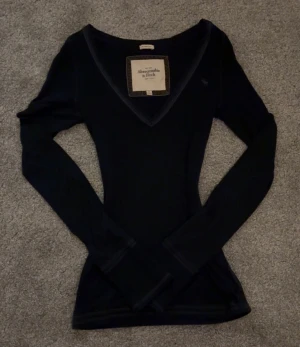 mörkblå v-ringad topp Abercrombie & Fitch -   ⊹ . ° ❥  stil? ➻ super söt mörkblå 2000s bella swan och elena gilbert style tröja från abercrombie & fitch tröja med v-ringning.         .    ⊹ . ° ❥ äkta? ➻ äkta vintage, köpt på en liten second hand i polen <3                                            . ⊹ . ° ❥ skick? ➻ som ny! inga tecken på användning <3 strl är M men den sitter som S