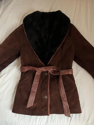 Äkta shearlingjacka från Amoress  - Äkta shearlingpälsjacka från Amoress Stockholm i storlek S!   Utsida i äkta mörkbrun mocka och insida i mörkbrun fårpäls. Premiumkvalitet med mycket hög värmehållning.  Nypris 15 000- 20 000kr (ca pris då jackan inte finns att köpa längre). Den är i mycket fint skick!