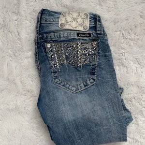 Miss Me jeans med strass och broderi - Jättefina lågmidjade miss me jeans, säljer då dem börjar bli för korta allt under 171 skulle jag säga att de passar i längden, dem är i bra skick men ett Penn sträck på låret vid jeansen men absolut inget man tänker på. Jag har sytt så att den blir mer lowaist skulle säga att den är storlek 23 istället för 26 nu!❤️