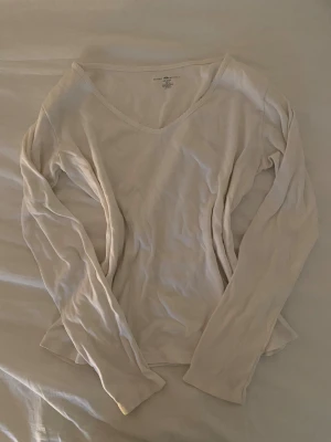 Vit långärmad topp från Brandy Melville - Säljer en enkel och stilren vit långärmad topp från Brandy Melville. Tröjan har en ribbad v-ringning och är supermysig inför vintern!❄️