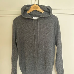 Grå Kashmir/merino hoodie från Tiger of Sweden - Lite nopprig men syns inte vid användning. Väldigt bra skick annars! Storlek xs, jag som är 178 har precis vuxit ur den. Hör av er vid frågor