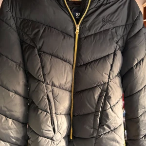 Svart pufferjacka från Svea! - Snygg svart pufferjacka från Svea i storlek S med fickor fram och huva. Jackan är i perfekt skick! 