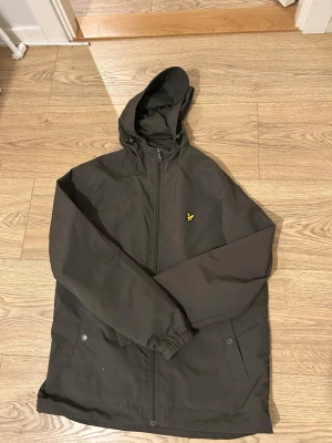 Olivgrön Lyle&Scott vindjacka. - Varm vindjacka från Lyle&Scott. Använd 6-7 gånger så i nästan perfekt skick. Säljer pga. Köpt Fel storlek, orginal pris: 800. Om frågor eller liknande finns skriv till mig!