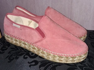 Rosa espadrillos från Odd Molly - Säljer ett par snygga rosa espadrillos från Odd Molly med ovandel i mocka och flätad jutesula. Insidan har ett färgglatt blommigt mönster och logotyp. Skorna har platt sula och rund tå, perfekta för sommarens alla dagar.
