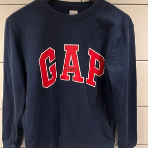 Blå tröja från GAP - Snygg mörkblå sweatshirt från GAP med logga på bröstet. Nypris 400kr. Passar 14-16 år alltså ungefär 165-180cm/storlek S.