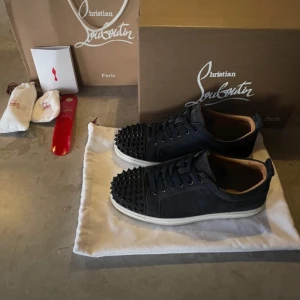 Christian Louboutin svarta sneakers med nitar - Säljer ett par riktigt schyssta Christian Louboutin skor i en sällsynt model som inte tillverkas längre samt svåra att få tag på.Skick 9/10 använda få gånger. Storlek 41 men sitter som 42. Nypris runt 8000-10000kr mitt pris endast 3500kr. Allt OG ingår. Priset kan justeras vid snabb och smidig affär. Hör av er vid frågor samt funderingar!