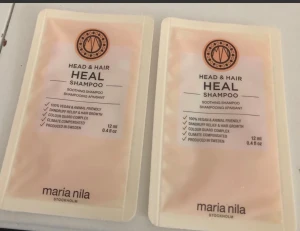 Maria Nila Head & Hair Heal Shampoo - Två små förpackningar med Maria Nila Head & Hair Heal Shampoo, 12 ml vardera. Schampot är veganskt, djurvänligt och tillverkat i Sverige. Designen är ljusrosa med svart text och logga. Perfekt för att testa eller ta med på resan.