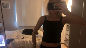 Svart croppad linnetopp - Säljer en svart, enkel och croppad linnetopp med raka axelband. Toppen är ärmlös och har en tight passform som sitter snyggt mot kroppen. Perfekt att matcha med jeans eller kjol för en clean look.