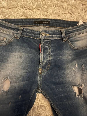 Dsquared2 jeans - Säljer dessa skit feta jeans från Dsquared2. Jeansen har snygga slitningar fram och snygg fade i färgen. Storlek 32 passar 175-180