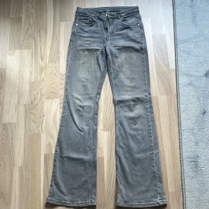 Grå bootcut jeans i storlek 158 - Snygga grå mid waist jeans  med bootcut-modell och klassisk femficksdesign. Jeansen har dragkedja och knapp framtill samt bälteshällor. 