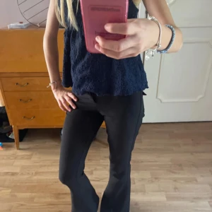 Svarta bootcut-byxor Gina Tricot XS - Säljer ett par svarta bootcut-byxor från Gina Tricot i storlek XS. Byxorna har låg midja, två knappar och dragkedja framtill samt fickor med  knapp bak. Snygg passform och stilren look, perfekta till många outfits. Bra i längden på mig som är ca 160! Pris går att diskutera 💞