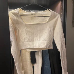 Vit croppad långärmad topp Aim'n - Säljer en vit croppad långärmad topp från Aim'n med fyrkantig ringning. Funkar både till träning och till vardags! 