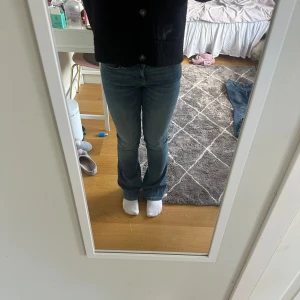 Blå bootcut jeans från Zara, stl 36 - Säljer ett par klassiska blå bootcut jeans från Zara i storlek 36. Jeansen har normal passform, fem fickor och snyggt utsvängda ben. Tillverkade i jeansmaterial med en lätt tvättad look. Perfekta till sneakers eller boots.