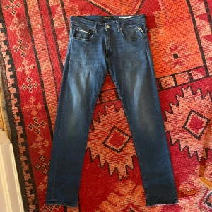 Replay Grover straight jeans blå - Säljer ett par snygga Replay Grover jeans i klassisk blå tvätt. Modellen är straight fit med normal passform och raka ben. Jeansen har fem fickor, diskreta slitningar(Dm:a om du vill se mer av dem mycket små slitningarna) och detaljer i orange vid myntfickan. Perfekta för dig som gillar stilrena och tidlösa jeans. Orginal pris: 1110kr🫠 mitt pris: 449kr!😍
