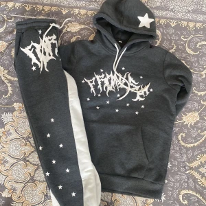 Grå hoodie med vit ”angel” print - Snygg och bekväm hoodie med byxor i grått coolt ”Angels” - tryck och stjärndetaljer på framsidan. Perfekt för vardag , streetwear eller mysig dagar hemma. Unisex - model som passar både tjej och killar 