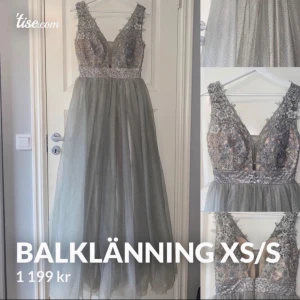 Ljusgrå balklänning med spetsdetaljer - Säljer en elegant ljusgrå balklänning i lång modell med v-ringad spetsliv och glittriga detaljer. Kjolen är i tunt, flowy material med diskret prickigt mönster. Midjan är markerad med ett glittrigt band och klänningen har ärmlös design. Perfekt för bal eller student! Byst: 85 cm Midja: 67 cm Höfter: 93 cm Längd från halsgrop till nedre fåll: 147 cm