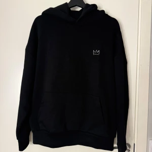 Hov1 merch svart hoodie  - Svart hoodie från Hov1 med en liten krona framtill och stort vitt turnétryck på ryggen med texten 'Vi Dansar Vidare I Livet' och turnédatum. Har en ficka på magen och en bekväm luva. Ska inte ljuga den sitter riktigt bra och är väldigt skön att ha på sig men jag är medveten om att detta är nog inget jag kommer att använda så ofta. Köptes på deras sista konser, på Gärdet i Stockholm och jag har enbart testat den en gång efter köpet. Pris kan diskuteras!