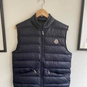 Moncler gui väst - Mörkblå Moncler gui väst i storlek 1, motsvarande XS-S. Västen är i jättefint skick, det ända är att fickorna är svår stängda. Tveka inte på att höra av dig vid minsta fundering😄 PRIS KAN DISKUTERAS