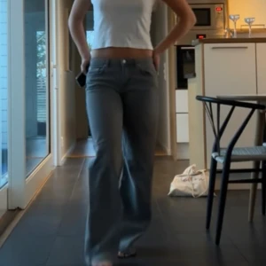 Lågmidjade gråajeans - Säljer ett par gråa jeans från NA-KD i klassisk bootcut-modell. Jeansen har fem fickor, normal passform och är tillverkade i ett mjukt bomullsmaterial med lite stretch. Nästan aldrig använda.