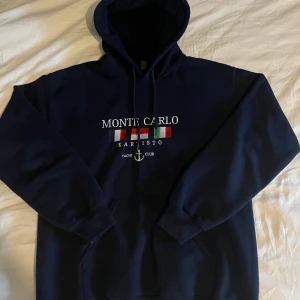 Mörkblå Monte Carlo hoodie med tryck - Snygg mörkblå hoodie med monte carlo tryck och 3 flagor. Riktig fett!  Nästan aldrig använd och inga defekter storlek s 