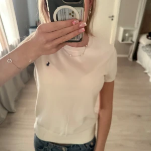 Ny med lapp kvar vit finstickad t-shirt från Polo Ralph Lauren - Ny med lapp kvar finstickad vit t-shirt från Polo Ralph Lauren med klassisk mörkblå broderad logga på bröstet. T-shirten heter cotton crewneck short-sleeve swether-rundhalsad som är kortärmad och finstickad🤍kan diskutera pris men köpte för 2195kr 