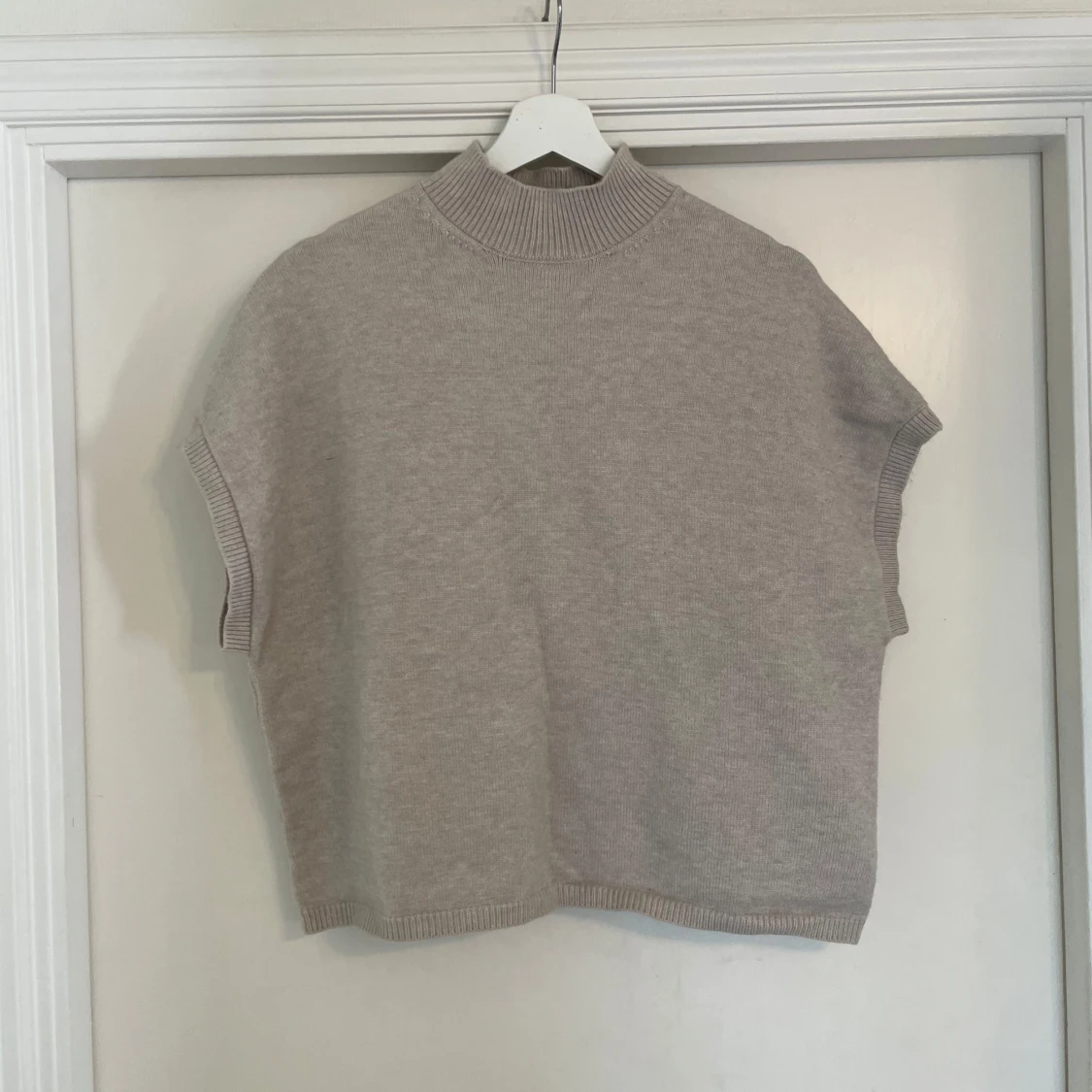 Beige stickad väst med hög krage