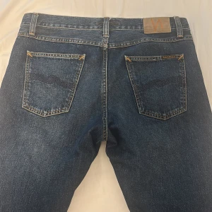 Nudie jeans steady Eddie  - Hej! Säljer ett par fina jeans från Nudie Jeans, de är av riktigt bra kvalitet och är knappt använda! De är storlek 32/32 och är relativt raka i passformen.