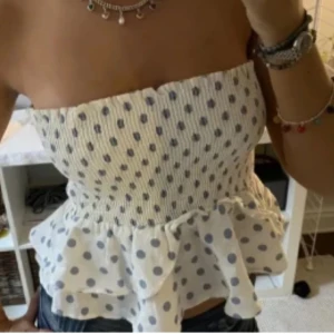 Vit prickig bandeau tubtopp - Supersöt vit bandeau tubtopp med blå prickar och volang nertill från zara. ( inte min bild)💗