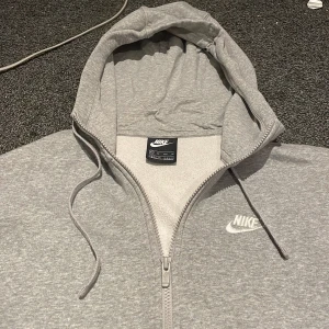 Grå Nike hoodie - Säljer grå nike hoodie som har blivit för liten. Storlek xs 