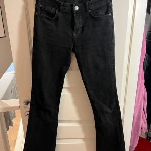 Svarta bootcut jeans från Bershka - Snygga svarta jeans från Bershka i bootcut-modell. Jeansen har hög midja, klassiska fem fickor och är tillverkade i ett stretchigt bomullsmaterial. Perfekta för dig som gillar en retroinspirerad look med utsvängda ben. säljer på grund av att de är för korta är 176