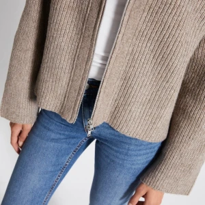 Brun/beige stickad zip up - Snygg stickad zip up. Knappt använd och är i fint skick. Jätte skön och långa ärmar perfekt för en kallare och mysig dag. 