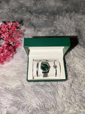 Rolle klockset med grön urtavla - Snyggt klockset från Rolle med en stilren silverfärgad länkarmband och grön urtavla. Klockan har en rund form och glittrande stenar runt boetten. Setet inkluderar två matchande armband, varav ett med Rolle-logga. Allt levereras i en grön och vit box med guldfärgad logotyp.