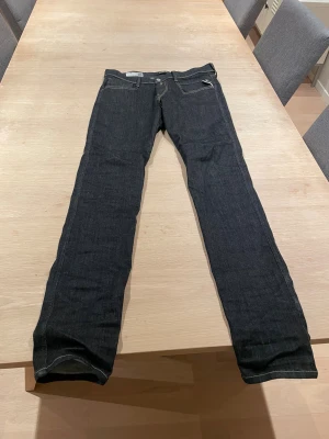Replay Hyperflex Anbass jeans slim fit - Snygga mörkblå Replay Hyperflex Anbass jeans i slim fit med klassisk femficksdesign och kontrastsömmar. Byxorna har en skinnpatch med Replay-logga bak och är gjorda i stretchigt jeansmaterial för extra komfort. Passar dig som gillar en smal siluett. Använda ungefär tre gånger