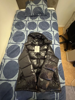 Svart pufferjacka från Moncler - Säljer en svart pufferjacka från Moncler maya. Perfekt för kalla dagar och har en riktigt snygg stil. Kan både mötas upp och frakta