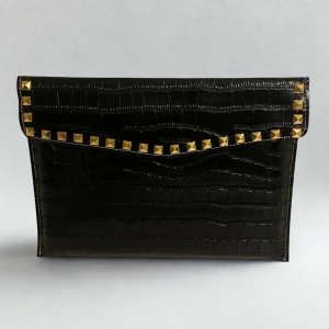 Dator fodral i krokodilimitation med guld nitar - Black Friday! 🖤 Ta del av vårt erbjudande för endast 199 kr! NY PREMIUM KOLLEKTION🥂Ett stilrent datorfodral tillverkad av krokodilmönstrat veganskt läder, som är handgjort och egendesignat. Fodralet är tillverkat i ett vattentätt och skyddande material för att ge din dator ett säkert skydd mot stötar och fukt. Mått 34,5 x 25 cm och passar Chromebook och andra datorer i liknande storlek. Rymmer dator, anteckningsblock och laddare. Leverans 3-5 arbetsdagar! 📦