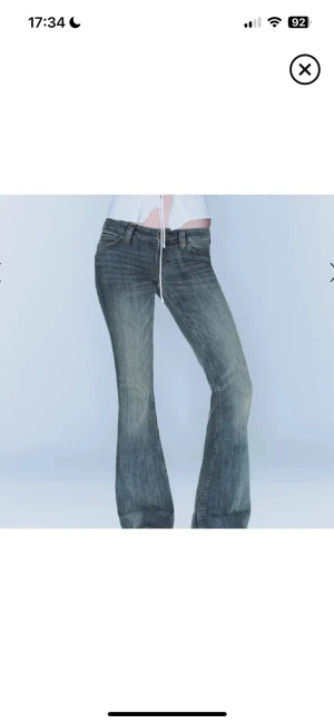 Bootcut jeans i blå denim - Snygga bootcut jeans från Cheap money i blå tvättad denim med låg midja. Klassisk femficksmodell, med detaljerad patch bak och slitningar framtill. Jeansen har en lätt utsvängd passform och är perfekta för dig som gillar retrovibbar och cool streetstil.